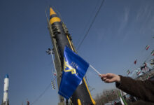 A man is waving a flag of the Islamic Revolutionary Guard Corps (IRGC) in front of the Iranian-made Kheibar Surface-to-Surface missile at Azadi (Freedom) Square in western Tehran, Iran, on February 11, 2024, during a rally to mark the 45th anniversary of the victory of Iran's 1979 Islamic Revolution. The Iranian Islamic Revolution, which led to the overthrow of the Pahlavi dynasty in 1979, replaced the Imperial State of Iran with the present-day Islamic Republic of Iran. (Photo by Morteza Nikoubazl/NurPhoto) (Photo by Morteza Nikoubazl / NurPhoto / NurPhoto via AFP)