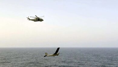 The Royal Navy's Merlin helicopter flying above the Puma drone over the ocean